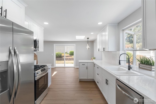 10218 63rd Avenue Ct E, Puyallup, WA 98373 - kitchen featuring appliances with stainless steel finishes, a skylight, plenty of natural light, light wood-style floors, and recessed lighting