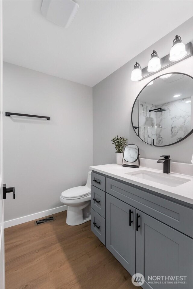 10218 63rd Avenue Ct E, Puyallup, WA 98373 - bathroom featuring a marble finish shower, vanity, and wood finished floors