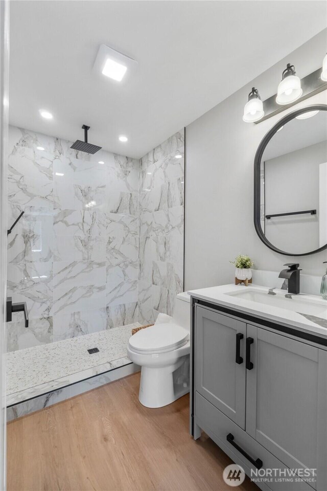 10218 63rd Avenue Ct E, Puyallup, WA 98373 - full bathroom featuring vanity, a marble finish shower, and wood finished floors