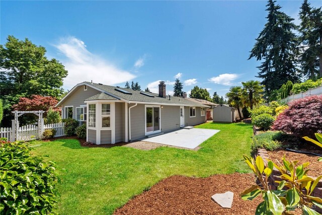 10218 63rd Avenue Ct E, Puyallup, WA 98373 - rear view of house with a patio, a chimney, an outbuilding, and roof with shingles