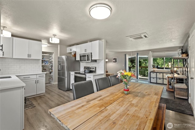 1216 NE Vena Ave, Bremerton, WA 98311 - dining space with a textured ceiling and light wood finished floors