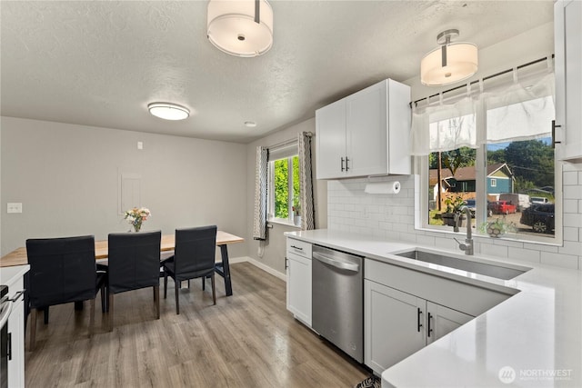 1216 NE Vena Ave, Bremerton, WA 98311 - kitchen featuring dishwasher, light countertops, decorative backsplash, light wood-type flooring, and a textured ceiling