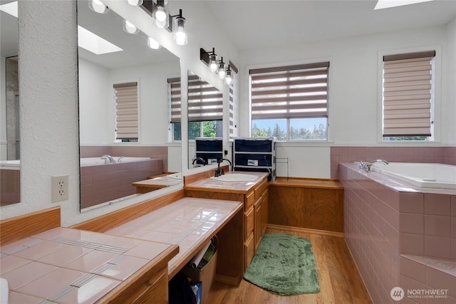 6314 75th Avenue Ct W, University Place, WA 98467 - bathroom featuring a skylight, wood finished floors, a garden tub, and vanity