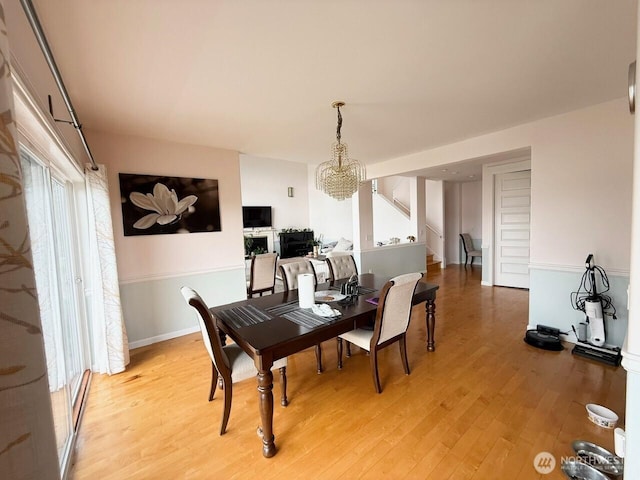 9844 Arrowsmith Ave S, Seattle, WA 98118 - dining room with a chandelier, light wood-style flooring, and stairway