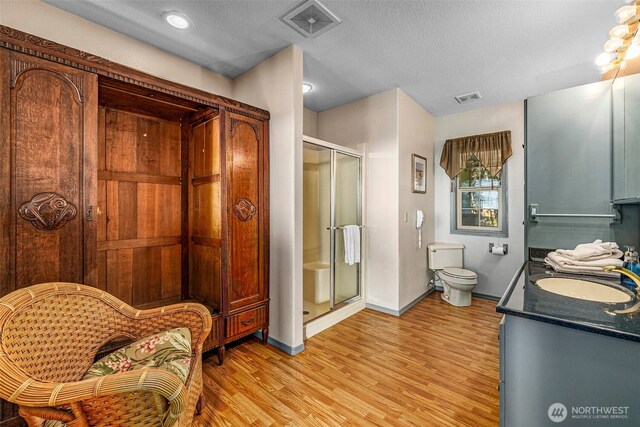 23309 J Pl, Ocean Park, WA 98640 - full bathroom featuring a stall shower, wood finished floors, double vanity, and a textured ceiling