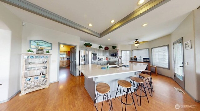 23309 J Pl, Ocean Park, WA 98640 - kitchen featuring light wood-style floors, appliances with stainless steel finishes, crown molding, light countertops, and a kitchen bar