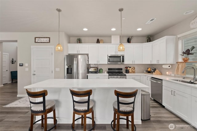 3115 Stephanie Loop NE, Lacey, WA 98516 - kitchen with stainless steel appliances, a kitchen island, backsplash, white cabinets, and recessed lighting