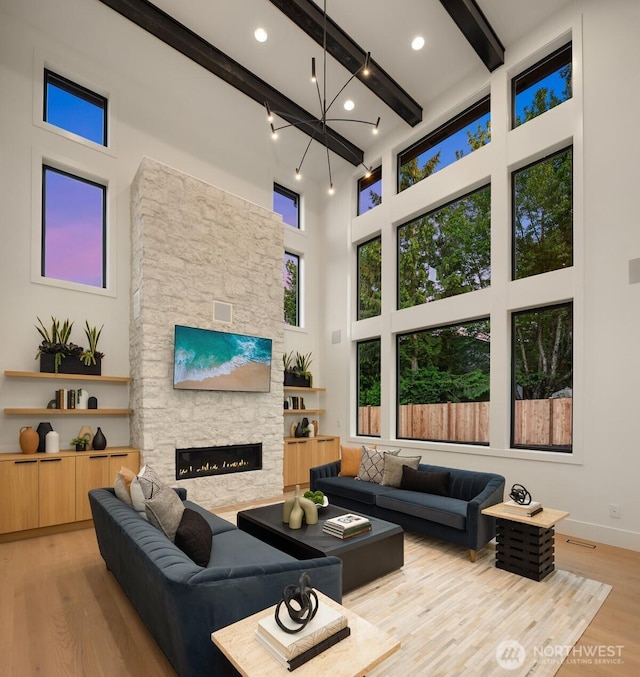 10425 NE 28th Pl, Bellevue, WA 98004 - living room with beamed ceiling, wood finished floors, a towering ceiling, a fireplace, and a chandelier