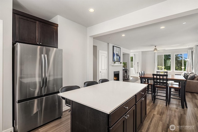 27156 NE Walden Way, Duvall, WA 98019 - kitchen featuring freestanding refrigerator, open floor plan, a lit fireplace, wood finished floors, and dark brown cabinets