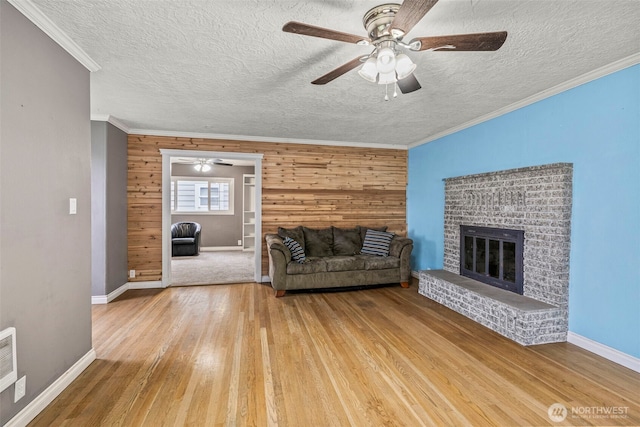 516 26th Ave, Longview, WA 98632 - living room with wood finished floors, ceiling fan, a brick fireplace, wood walls, and a textured ceiling