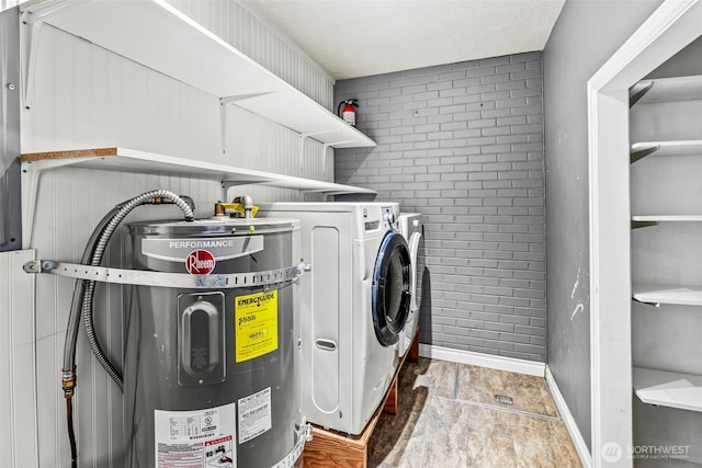 516 26th Ave, Longview, WA 98632 - laundry room featuring strapped water heater, washer and dryer, and brick wall