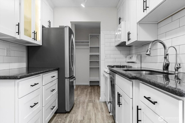 5029 84th St SW Unit 109, Mukilteo, WA 98275 - kitchen with tasteful backsplash, white cabinetry, light wood-type flooring, and dark stone countertops