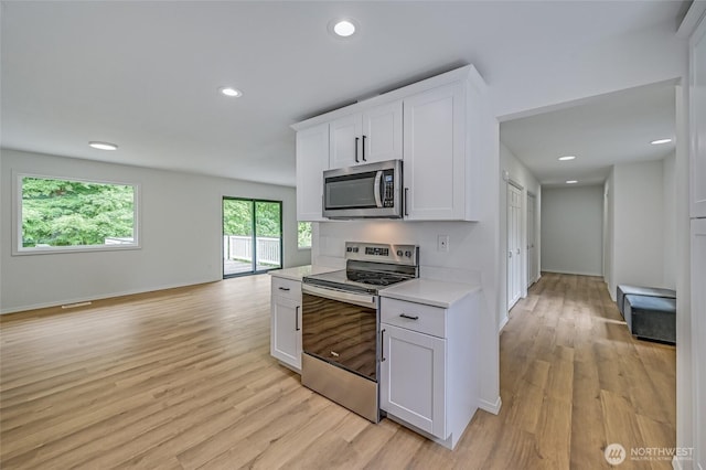 13428 SE 302nd Pl, Auburn, WA 98092 - kitchen with appliances with stainless steel finishes, light countertops, light wood-style flooring, white cabinetry, and recessed lighting