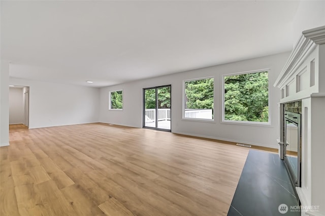 13428 SE 302nd Pl, Auburn, WA 98092 - unfurnished living room featuring light wood-style flooring and a glass covered fireplace
