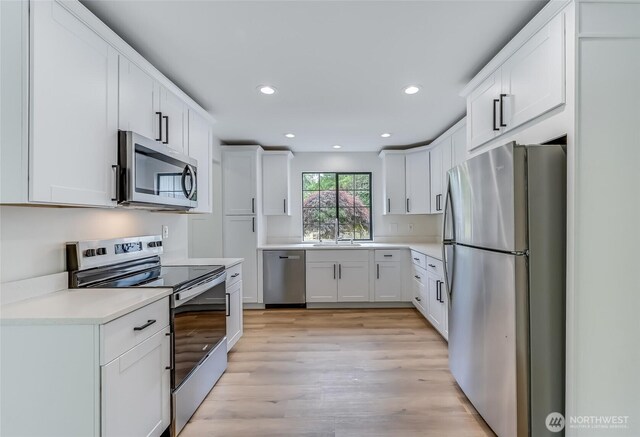 13428 SE 302nd Pl, Auburn, WA 98092 - kitchen featuring appliances with stainless steel finishes, light countertops, white cabinetry, recessed lighting, and light wood-type flooring
