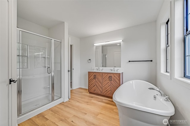 13428 SE 302nd Pl, Auburn, WA 98092 - full bathroom with double vanity, wood finished floors, a soaking tub, and a stall shower