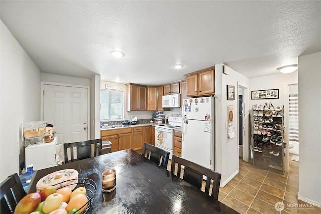 108 Baker St Unit 1-4, Everson, WA 98247 - kitchen featuring white appliances, a textured ceiling, tile patterned floors, recessed lighting, and brown cabinetry
