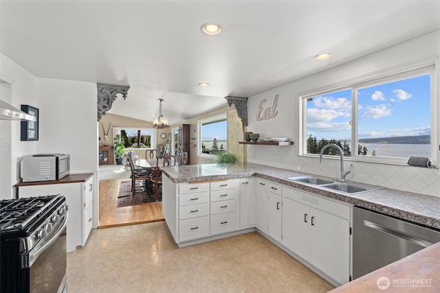 809 W Rocky Point Dr, Camano Island, WA 98282 - kitchen featuring appliances with stainless steel finishes, a chandelier, white cabinetry, tile counters, and tasteful backsplash