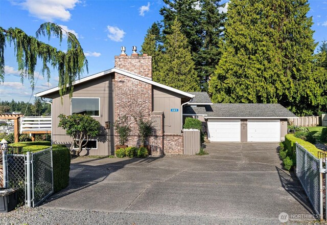 809 W Rocky Point Dr, Camano Island, WA 98282 - view of side of property featuring a garage, a chimney, brick siding, and driveway