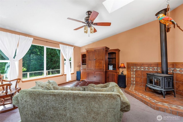 5626 Thane Ln SE, Port Orchard, WA 98367 - living area with carpet floors, vaulted ceiling, a wood stove, ceiling fan, and a skylight