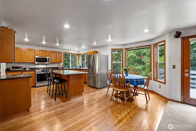6345 Agnes Rd NE, Tacoma, WA 98422 - kitchen featuring stainless steel appliances, dark countertops, light wood-style floors, a kitchen island, and recessed lighting