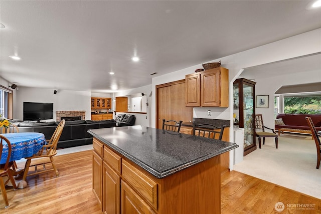 6345 Agnes Rd NE, Tacoma, WA 98422 - kitchen featuring a fireplace, a center island, recessed lighting, light wood-style floors, and brown cabinetry
