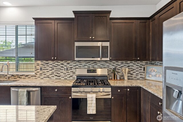 3119 13th Avenue Ct NW, Puyallup, WA 98371 - kitchen featuring stainless steel appliances, dark brown cabinetry, decorative backsplash, light stone counters, and recessed lighting