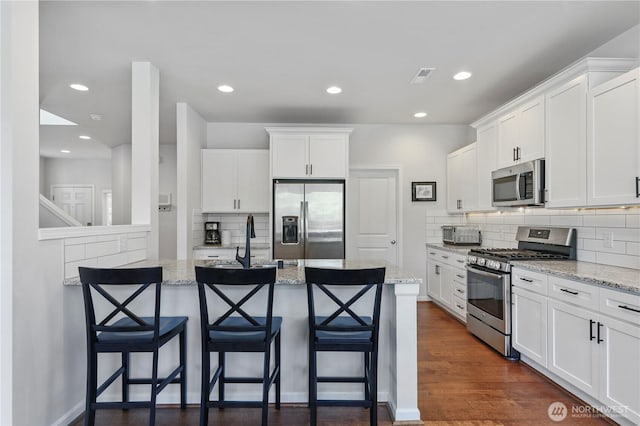 4508 29th Ave SE, Everett, WA 98203 - kitchen featuring appliances with stainless steel finishes, tasteful backsplash, a breakfast bar, white cabinetry, and recessed lighting