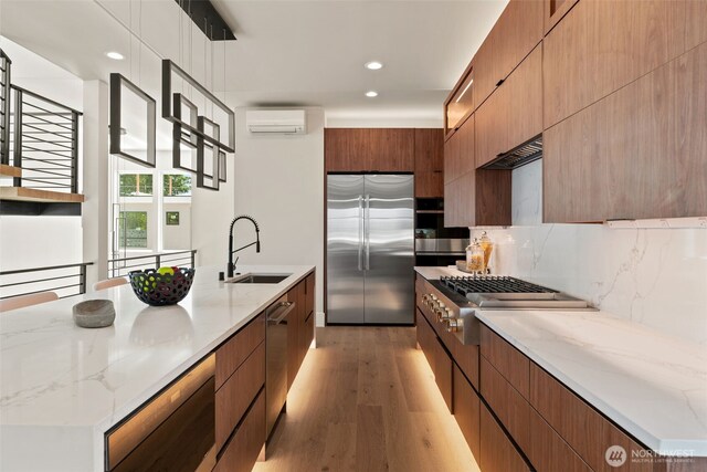 11888 SE 5th St, Bellevue, WA 98005 - kitchen featuring appliances with stainless steel finishes, modern cabinets, a wall unit AC, recessed lighting, and light wood finished floors