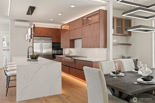 11888 SE 5th St, Bellevue, WA 98005 - kitchen with stainless steel appliances, a wall mounted air conditioner, modern cabinets, decorative backsplash, and brown cabinets