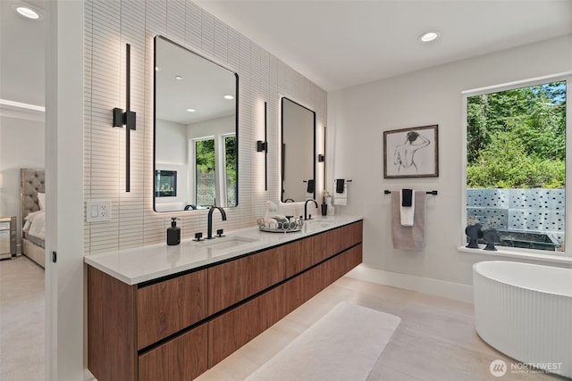 11888 SE 5th St, Bellevue, WA 98005 - ensuite bathroom featuring double vanity, a freestanding bath, decorative backsplash, and recessed lighting