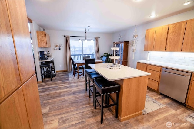 7 Sunset Lakes Rd, Omak, WA 98841 - kitchen with stainless steel dishwasher, a breakfast bar area, light countertops, a center island, and light wood finished floors