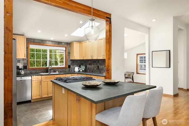 537 30th Ave E, Seattle, WA 98112 - kitchen featuring appliances with stainless steel finishes, dark countertops, vaulted ceiling, tasteful backsplash, and a kitchen bar