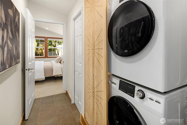 537 30th Ave E, Seattle, WA 98112 - laundry area with stacked washer and clothes dryer, dark tile patterned flooring, and dark colored carpet