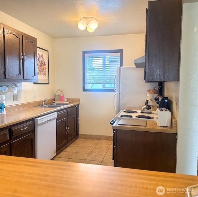 210 26th St NW Unit 106, Long Beach, WA 98361 - kitchen featuring white appliances, ventilation hood, dark brown cabinetry, light tile patterned floors, and light countertops