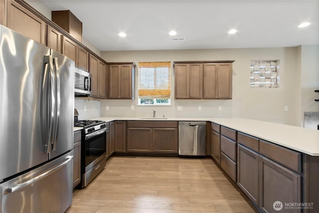1447 E 48th St, Tacoma, WA 98404 - kitchen featuring stainless steel appliances, a peninsula, light wood finished floors, light countertops, and recessed lighting