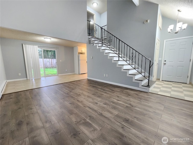 3624 159th Street Ct E, Tacoma, WA 98446 - unfurnished living room with high vaulted ceiling, wood finished floors, stairs, and a chandelier