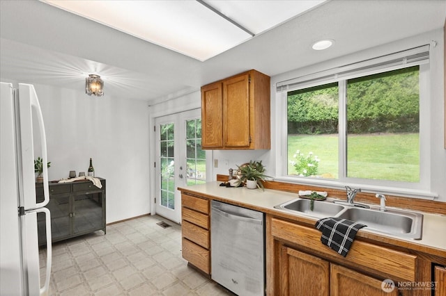 1513 Lowell Ave, Bellingham, WA 98229 - kitchen with dishwasher, freestanding refrigerator, light floors, brown cabinetry, and healthy amount of natural light