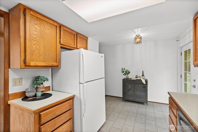 1513 Lowell Ave, Bellingham, WA 98229 - kitchen with light flooring, light countertops, brown cabinets, freestanding refrigerator, and dishwasher