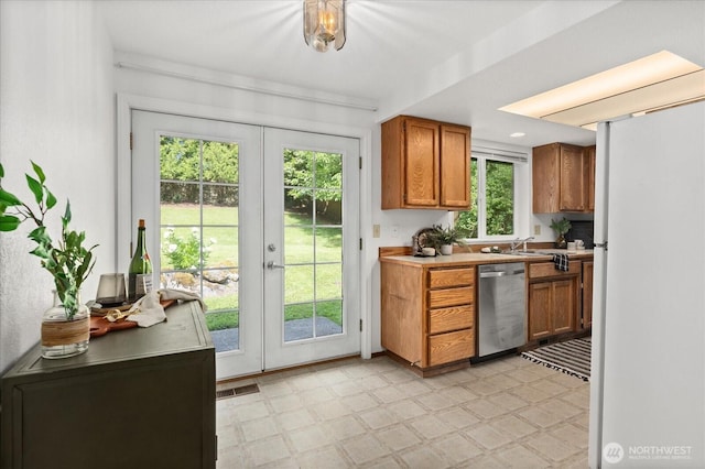 1513 Lowell Ave, Bellingham, WA 98229 - kitchen featuring stainless steel dishwasher, freestanding refrigerator, light floors, french doors, and brown cabinets