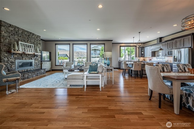 453 Spruce Ct NW, East Wenatchee, WA 98802 - living area with wood finished floors, a stone fireplace, recessed lighting, and ornamental molding