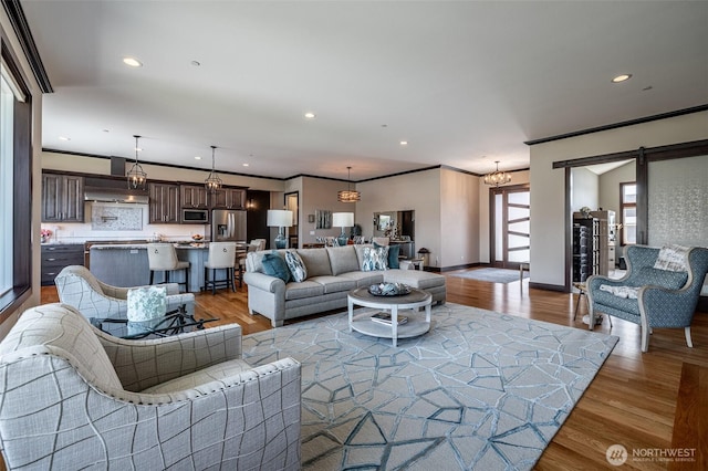 453 Spruce Ct NW, East Wenatchee, WA 98802 - living area with wood finished floors, recessed lighting, crown molding, a chandelier, and a barn door