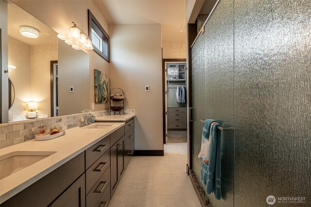 453 Spruce Ct NW, East Wenatchee, WA 98802 - full bathroom with double vanity, a tile shower, decorative backsplash, tile patterned floors, and a spacious closet