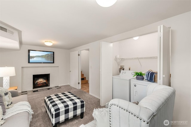 19508 23rd Ave NE, Shoreline, WA 98155 - living area featuring washer and dryer, a warm lit fireplace, stairs, and carpet flooring