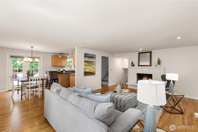 19508 23rd Ave NE, Shoreline, WA 98155 - living area featuring stairs, light wood-style flooring, a warm lit fireplace, a chandelier, and recessed lighting
