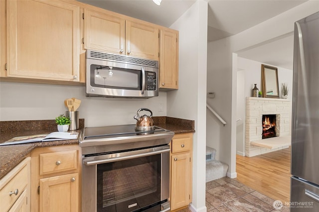 19508 23rd Ave NE, Shoreline, WA 98155 - kitchen with appliances with stainless steel finishes, light brown cabinetry, and a stone fireplace
