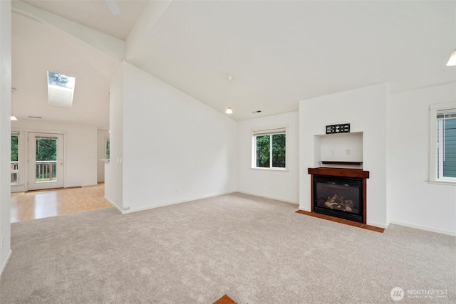 424 Wilson Ln, Sumas, WA 98295 - unfurnished living room with carpet floors, a fireplace with flush hearth, lofted ceiling, and a skylight