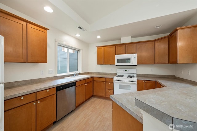 424 Wilson Ln, Sumas, WA 98295 - kitchen featuring white appliances, brown cabinets, light wood-style floors, recessed lighting, and light countertops