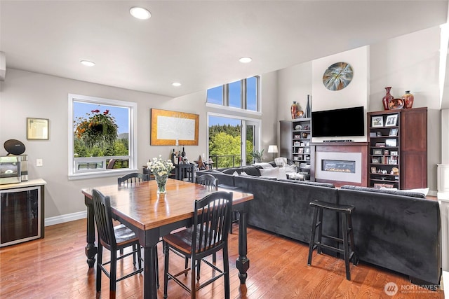 1301 Broad St, Bellingham, WA 98229 - dining area with wine cooler, a glass covered fireplace, light wood-style floors, and recessed lighting