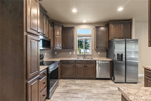 712 Syzygy Ct SE, Ocean Shores, WA 98569 - kitchen with stainless steel appliances, tasteful backsplash, light wood finished floors, recessed lighting, and dark brown cabinets